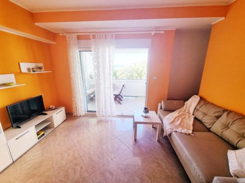 a living room with a couch and a television at House Šubić in Supetarska Draga