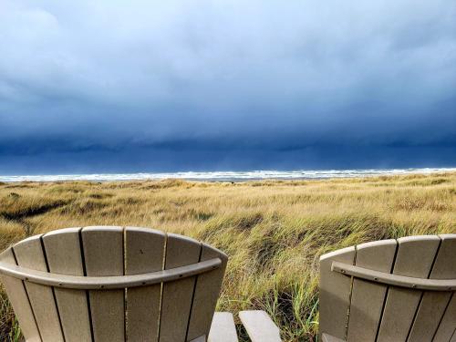 two trash cans sitting on the beach with a storm at Moonstone Beach Motel in Moclips