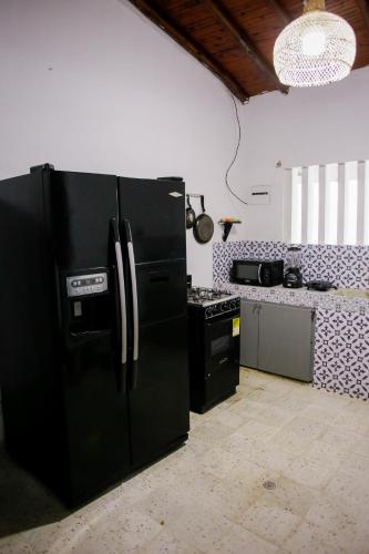 a kitchen with a black refrigerator and a stove at Cabaña Perla Azul in Coveñas