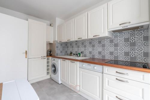 a kitchen with white cabinets and a washer and dryer at Disneyland-Paris 8pers, 2 Parkings, Wifi, Netflix in Serris
