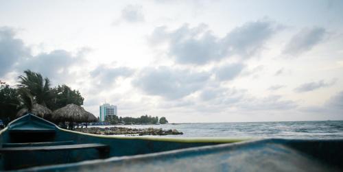 a boat on the ocean with a beach and a building at Cabaña Perla Azul in Coveñas