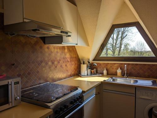 Il comprend une cuisine équipée d'une cuisinière et d'un évier. dans l'établissement Appartement Le Louis Dort au calme, à Équemauville