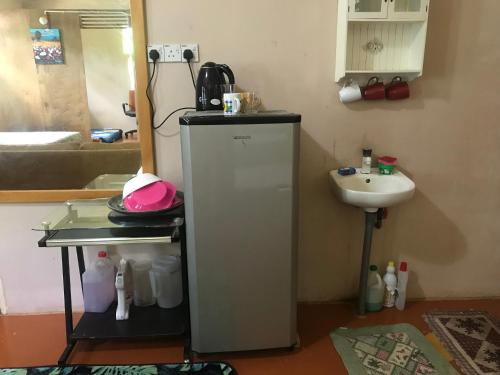 a bathroom with a small refrigerator and a sink at Anjung Afilia 1 in Kuala Kangsar