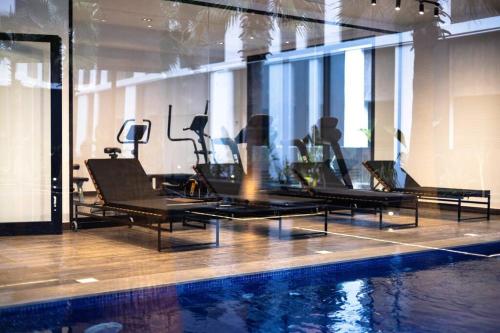 a gym with chairs and a swimming pool at Appartement Luxueux aux jardins de Carthage in Sidi Daoud