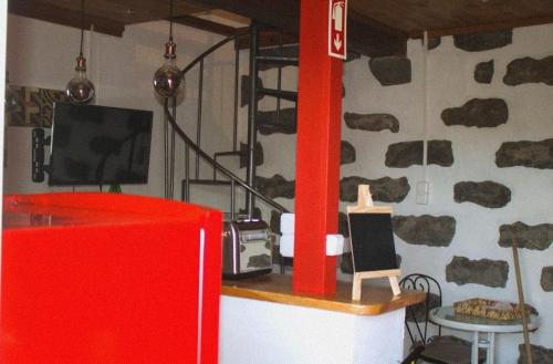 una stanza con una tv e una parete ricoperta di rocce di Um quarto da Casa Do Monte a Água de Alto