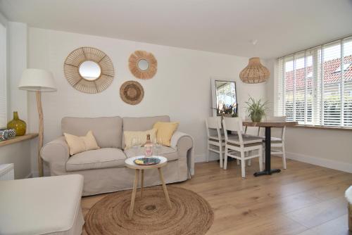 uma sala de estar com um sofá e uma mesa em Casa Feliz em Egmond aan Zee
