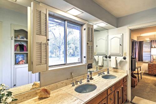 a bathroom with two sinks and a window at Mid-Century Brownsville Hideaway with Patio and Yard! in Brownsville