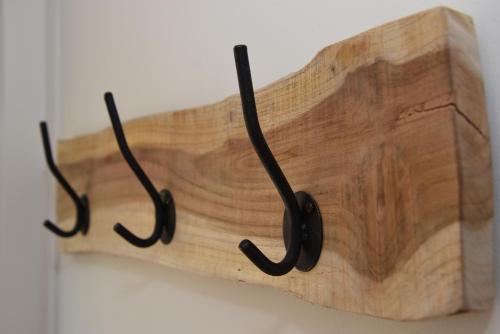 a wooden cutting board with black hooks on a wall at Casa Feliz in Egmond aan Zee