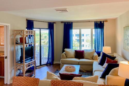 a living room with a couch and a tv at Port O'Call C-303 in Isle of Palms