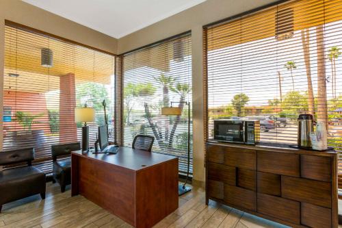 an office with a desk in a room with large windows at Royal Sun Hotel & Suites in Tucson