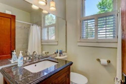 a bathroom with a sink and a toilet and a mirror at Island Charm1908 classic in the heart of downtown in Fernandina Beach