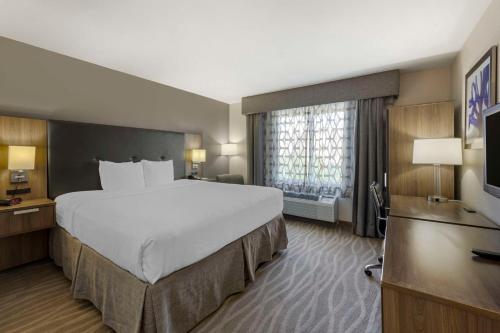 a hotel room with a large bed and a television at Best Western Plus Nashville Airport Hotel - BNA in Nashville