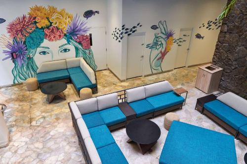 a living room with a couch and a painting of a woman at Waikiki Malia in Honolulu
