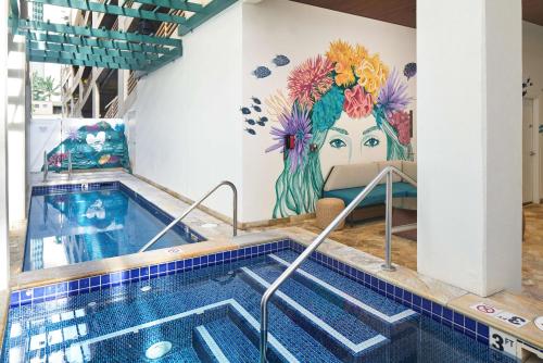 a swimming pool with a mural of a woman at Waikiki Malia in Honolulu
