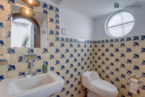 y baño con lavabo y paredes de azulejos azules y blancos. en Refurbished Mansion with Garden & Patio in Las Lomas - Monte Blanco, en Ciudad de México