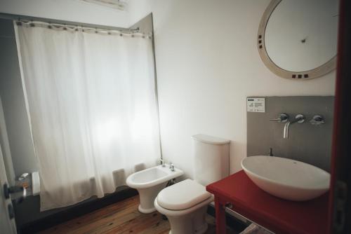 a bathroom with a toilet and a sink and a mirror at Posada Las Aguas in Gualeguaychú
