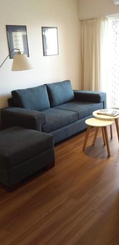 sala de estar con sofá azul y mesa en Puerto de Olivos 3 ambientes in 