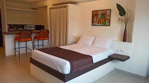 a bedroom with a bed and a table and chairs at La Gloria in Cancún