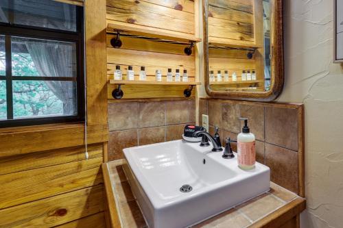 y baño con lavabo y espejo. en Beaver Lake Vacation Rental with Private Hot Tub! en Eureka Springs