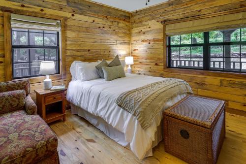 a bedroom with a large bed in a log cabin at Beaver Lake Vacation Rental with Private Hot Tub! in Eureka Springs