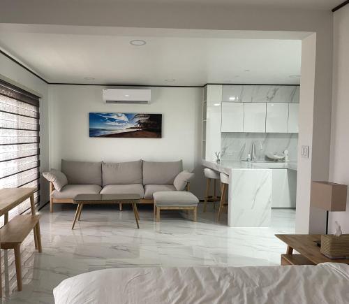 ein Wohnzimmer mit einem Sofa und einer Küche in der Unterkunft Mariana Suites in San Roque
