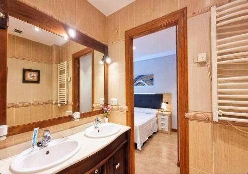 a bathroom with two sinks and a large mirror at Llanes Porrua VVValparon in Porrúa