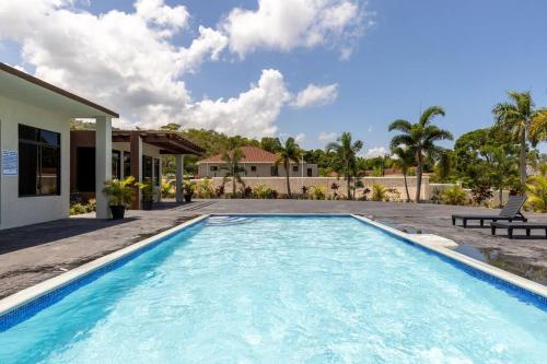 Sun Shine Luxury Villas 2 bedroom Pool & Gym Ocho Rios St Ann في أوتشو ريوس: مسبح في الحديقة الخلفية للمنزل