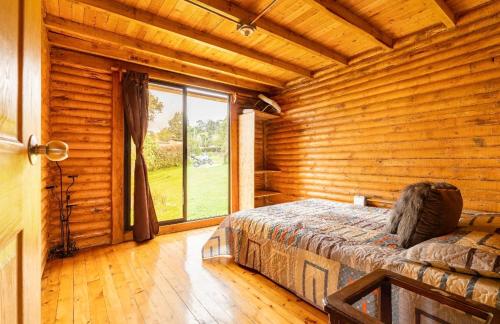 ein Schlafzimmer mit einem Bett und einem großen Fenster in der Unterkunft Mi lugar secreto in Medellín