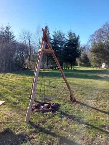 a wooden frame in the grass in a field at Natuurchalet de Das in Wehl