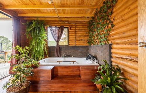 a bath tub in a wooden bathroom with plants at Mi lugar secreto in Medellín