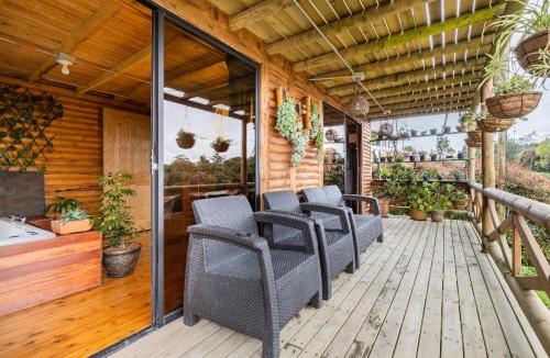 a porch with chairs on a wooden deck at Mi lugar secreto in Medellín
