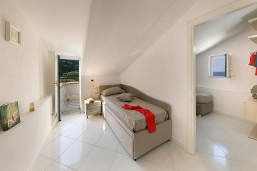 ein Schlafzimmer mit einem Bett in einem weißen Zimmer in der Unterkunft Relais del mare con terrazza fronte mare free parking in Massa Lubrense