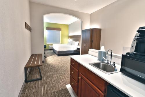 een hotelkamer met een wastafel en een slaapkamer bij Holiday Inn Express Hotel & Suites Goshen, an IHG Hotel in Goshen