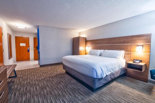 a large hotel room with a bed and a desk at Holiday Inn Express Hotel & Suites Goshen by IHG in Goshen