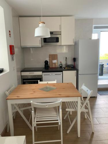 a kitchen with a table and chairs and a refrigerator at Fazenda Apartments - Apartment 1 in Lajes das Flores