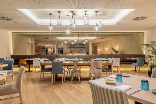 a restaurant with tables and chairs and a bar at Crowne Plaza - Caparica Lisbon in Costa da Caparica