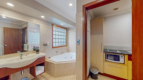 a bathroom with a sink and a bath tub at Quantum Lodge Motor Inn in Hamilton