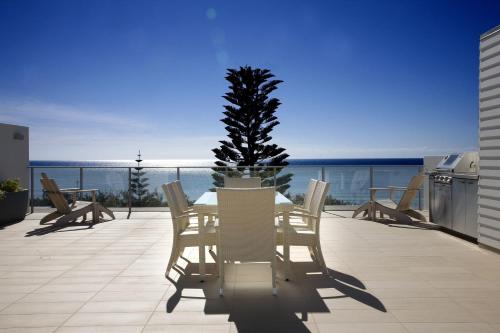a table and chairs on a balcony with a tree at Plantation Resort At Rainbow in Rainbow Beach