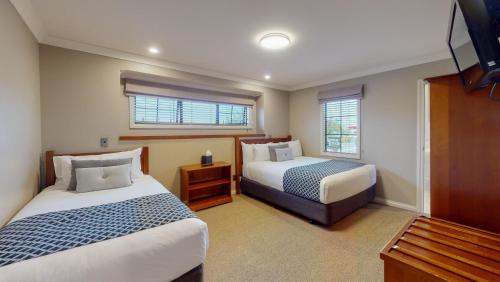 a hotel room with two beds and a window at Quantum Lodge Motor Inn in Hamilton
