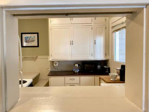 uma cozinha com armários brancos e um micro-ondas em Historic Downtown Riverview Flat, No. 1 em Astoria