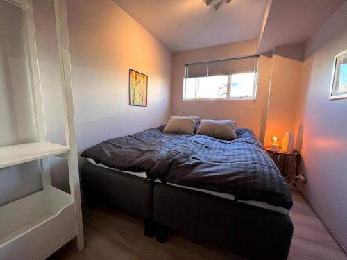 Dormitorio pequeño con cama y ventana en Lovely Apartment with 2-bedrooms and living room for 4 guests, max 6 - Seaside Neighborhood en Reikiavik
