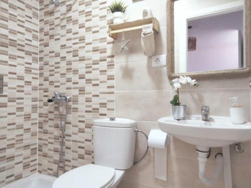 a bathroom with a toilet and a sink and a mirror at La casita in Arona