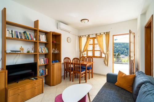a living room with a couch and a tv and a table at Rooms and Apartment Nike in Dubrovnik