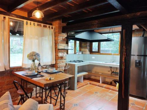 a kitchen with a table and a refrigerator at Tiny Chalet in the clouds in Medellín