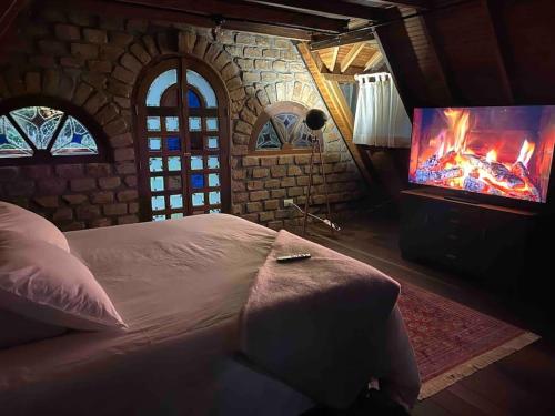 a bedroom with a bed and a flat screen tv at Tiny Chalet in the clouds in Medellín