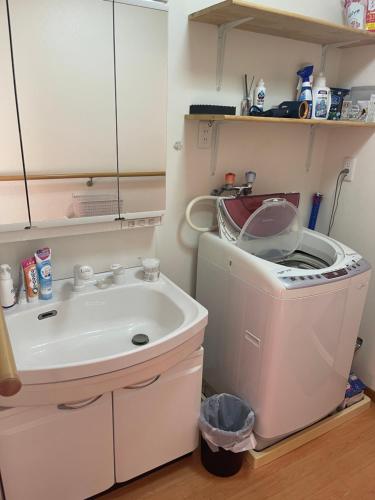 a bathroom with a sink and a washing machine at 高島市マキノ町民泊お得 in Takashima