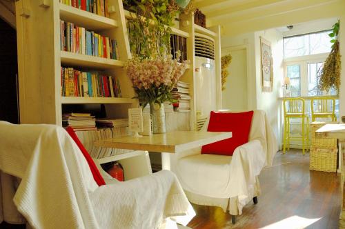 a living room with a table and chairs and bookshelves at Peking Youth Hostel in Beijing