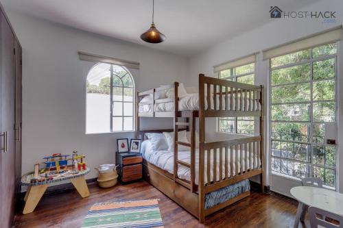 een slaapkamer met 2 stapelbedden en een tafel bij Refurbished Mansion with Garden & Patio in Las Lomas - Monte Blanco in Mexico-Stad