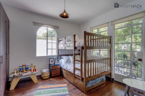 a bedroom with two bunk beds and a table at Refurbished Mansion with Garden & Patio in Las Lomas - Monte Blanco in Mexico City