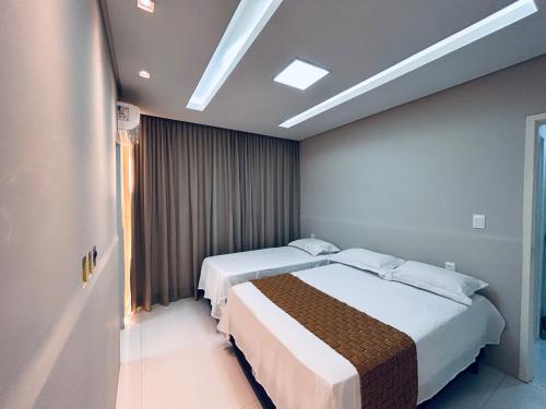 a hotel room with two beds and a window at Casa de férias São josé Maragogi in São José da Coroa Grande